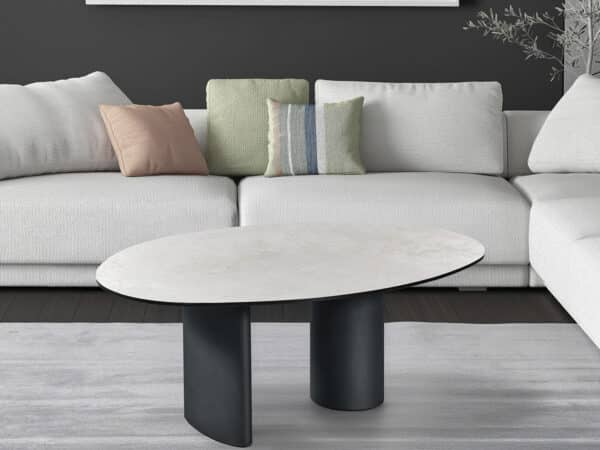 Light gray sectional sofa with pastel throw pillows and a round marble-top coffee table in a modern living room.